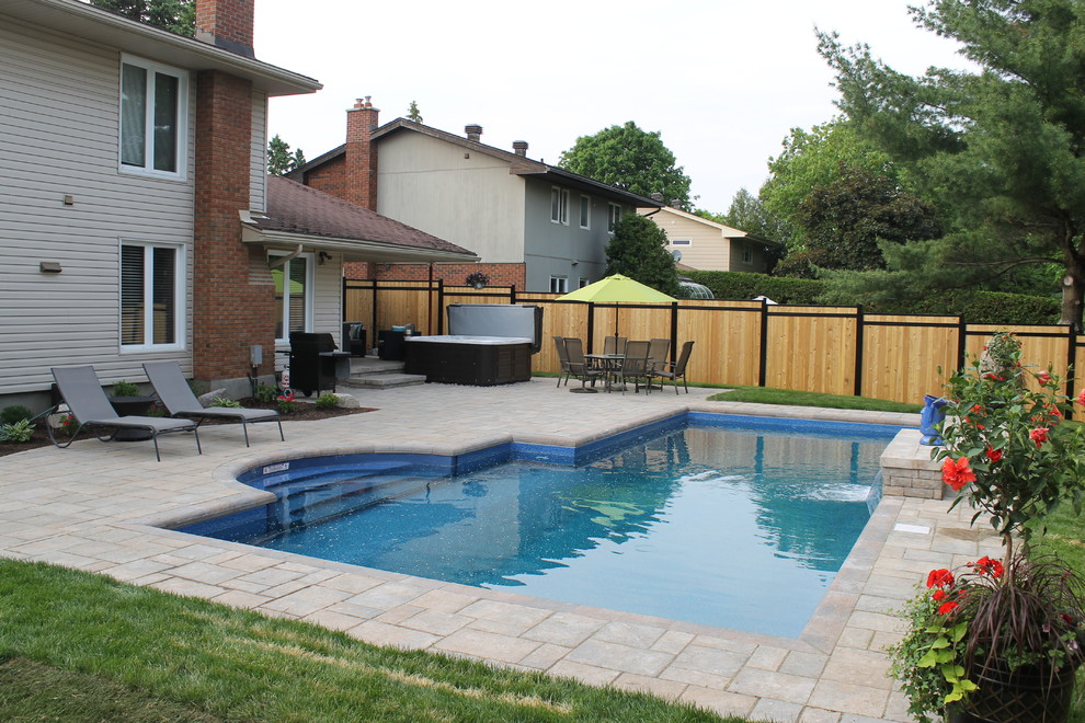 Immagine di una piscina naturale chic personalizzata di medie dimensioni e dietro casa con fontane e pavimentazioni in cemento