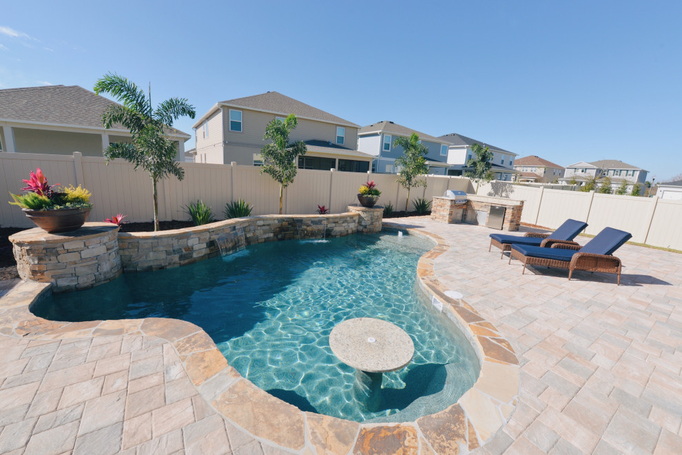 Foto di una piscina tropicale personalizzata di medie dimensioni e dietro casa con pavimentazioni in mattoni