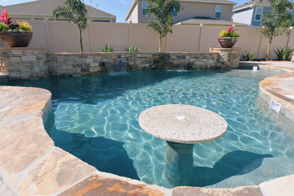 Modelo de piscina exótica de tamaño medio a medida en patio trasero con adoquines de ladrillo