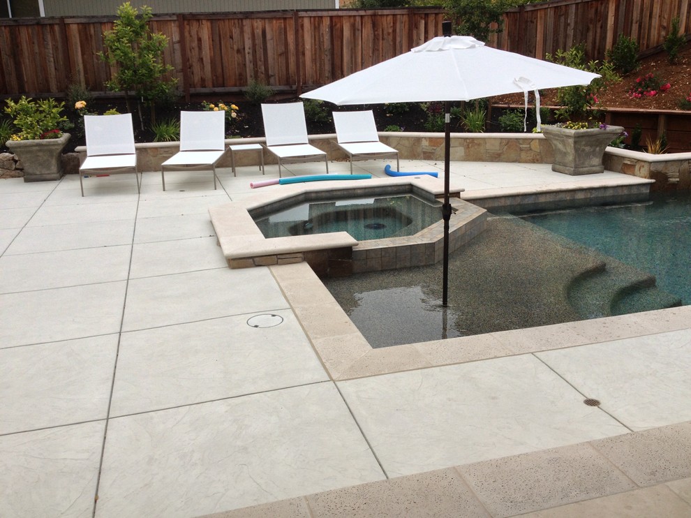 This is an example of a medium sized contemporary back custom shaped natural hot tub in San Francisco with stamped concrete.