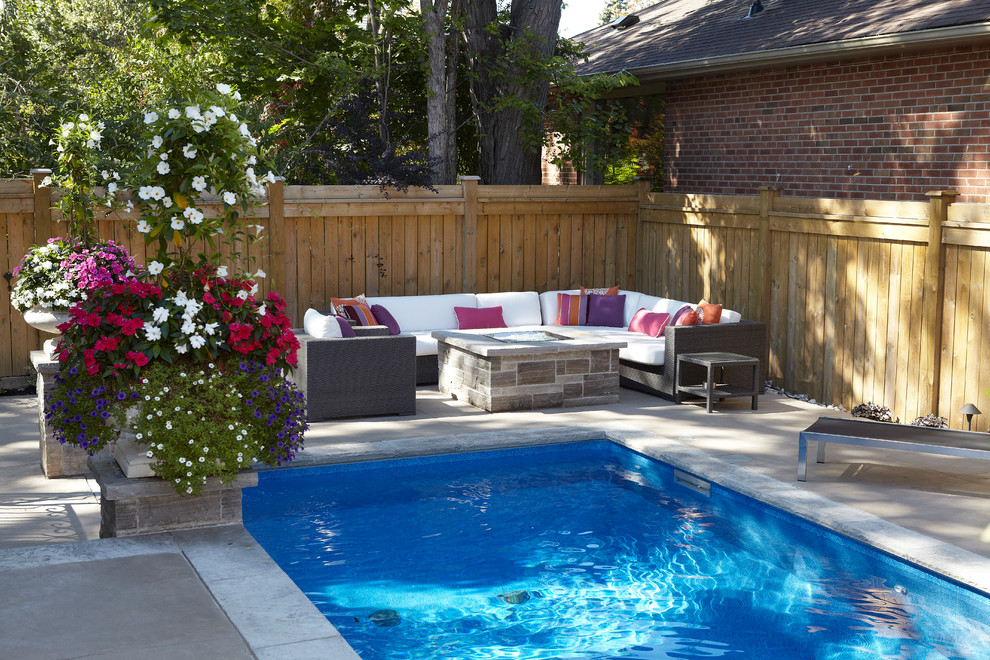 Imagen de piscina con fuente alargada actual de tamaño medio rectangular en patio trasero con adoquines de hormigón