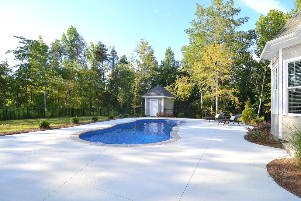 Свежая идея для дизайна: бассейн среднего размера, произвольной формы на заднем дворе в стиле неоклассика (современная классика) с домиком у бассейна и мощением тротуарной плиткой - отличное фото интерьера