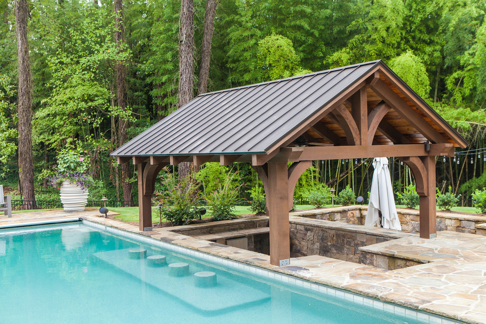 Ispirazione per una piscina american style rettangolare di medie dimensioni e dietro casa con pavimentazioni in pietra naturale