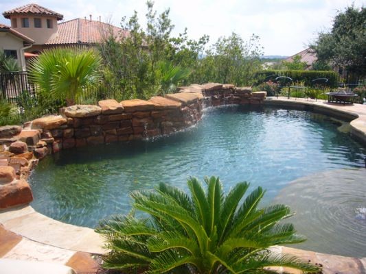 Bild på en tropisk anpassad pool på baksidan av huset