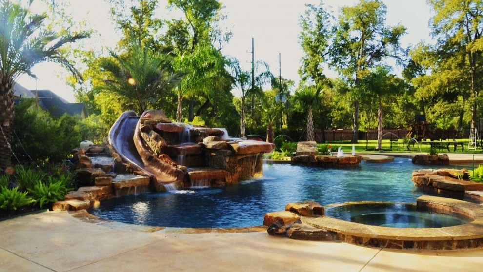 Immagine di una grande piscina naturale moderna personalizzata dietro casa con fontane e cemento stampato