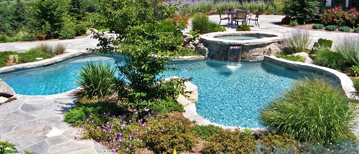 Esempio di una grande piscina minimalista personalizzata dietro casa con una vasca idromassaggio e cemento stampato