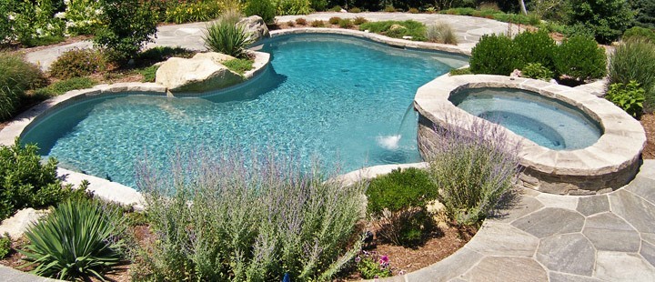 Diseño de piscinas y jacuzzis modernos grandes a medida en patio trasero con suelo de hormigón estampado