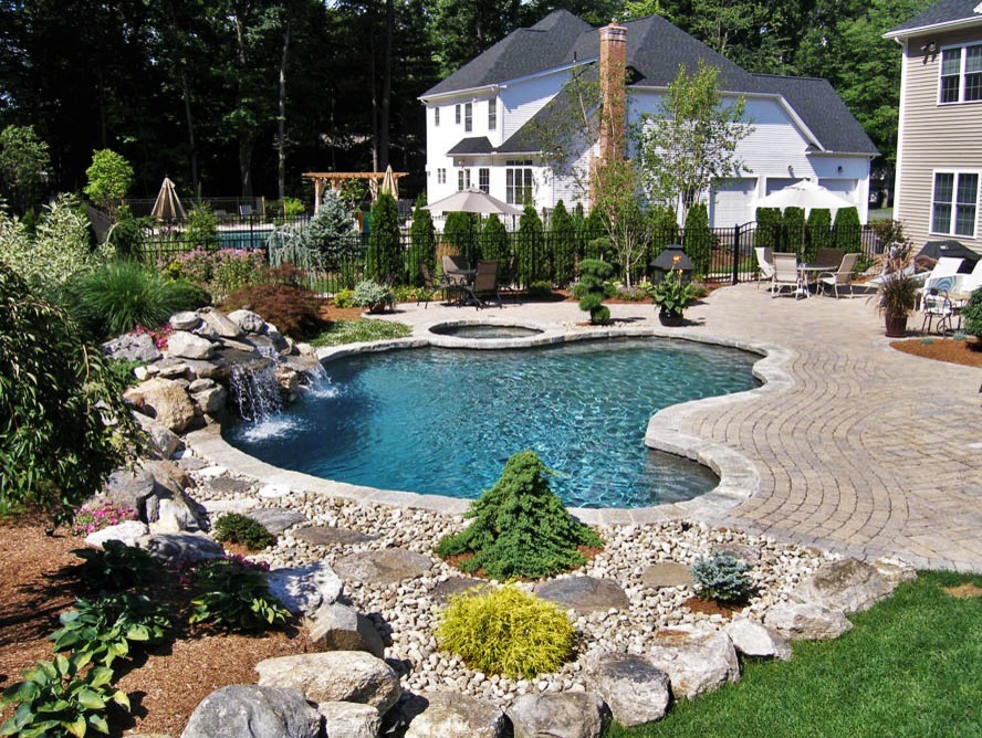 Idéer för att renovera en stor funkis anpassad pool på baksidan av huset, med spabad och stämplad betong