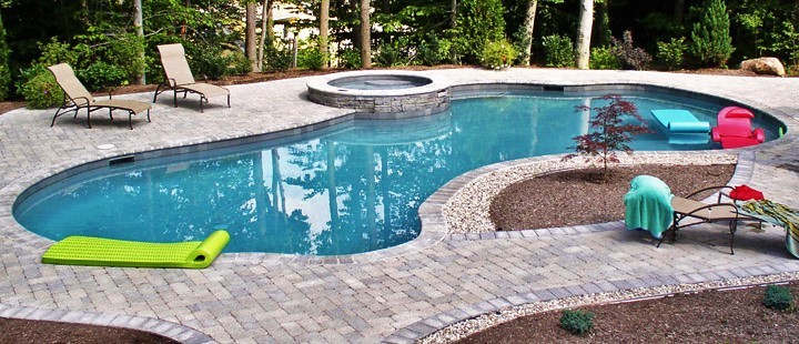 Inspiration för en stor funkis anpassad pool på baksidan av huset, med spabad och stämplad betong