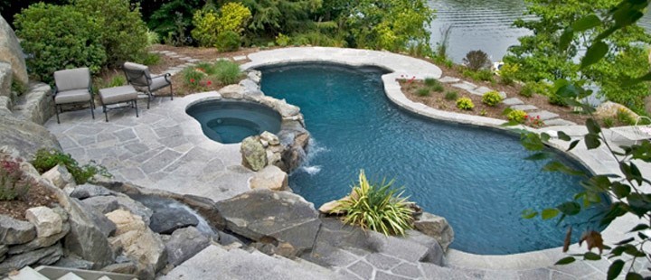 Cette photo montre une grande piscine arrière moderne sur mesure avec un bain bouillonnant et du béton estampé.