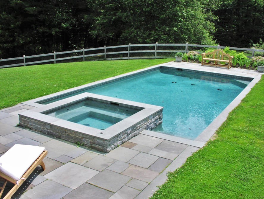 Diseño de piscinas y jacuzzis modernos grandes a medida en patio trasero con suelo de hormigón estampado
