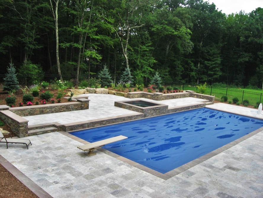Idee per una grande piscina moderna personalizzata dietro casa con una vasca idromassaggio e cemento stampato