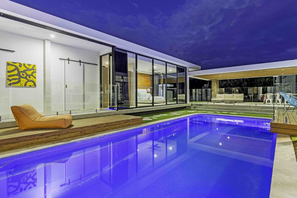 Idée de décoration pour une piscine design rectangle avec une cour et des pavés en pierre naturelle.