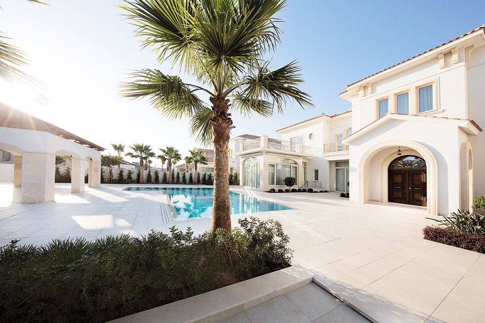 Idee per una grande piscina mediterranea personalizzata in cortile con pavimentazioni in pietra naturale