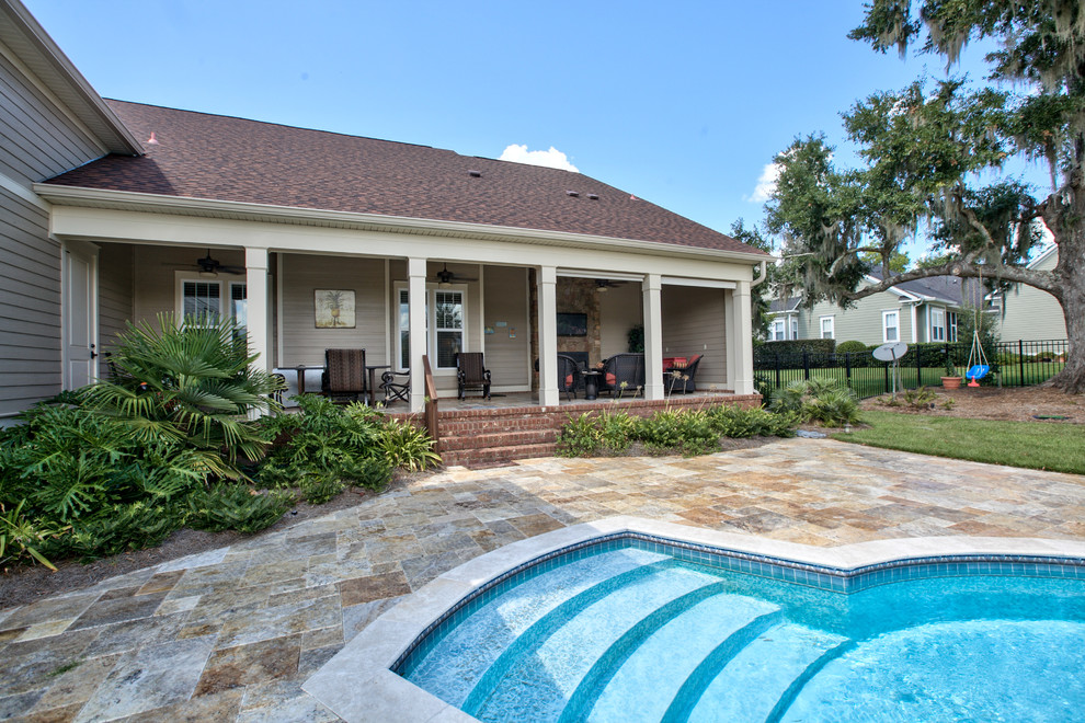 Diseño de piscina de estilo americano grande a medida en patio trasero con adoquines de piedra natural