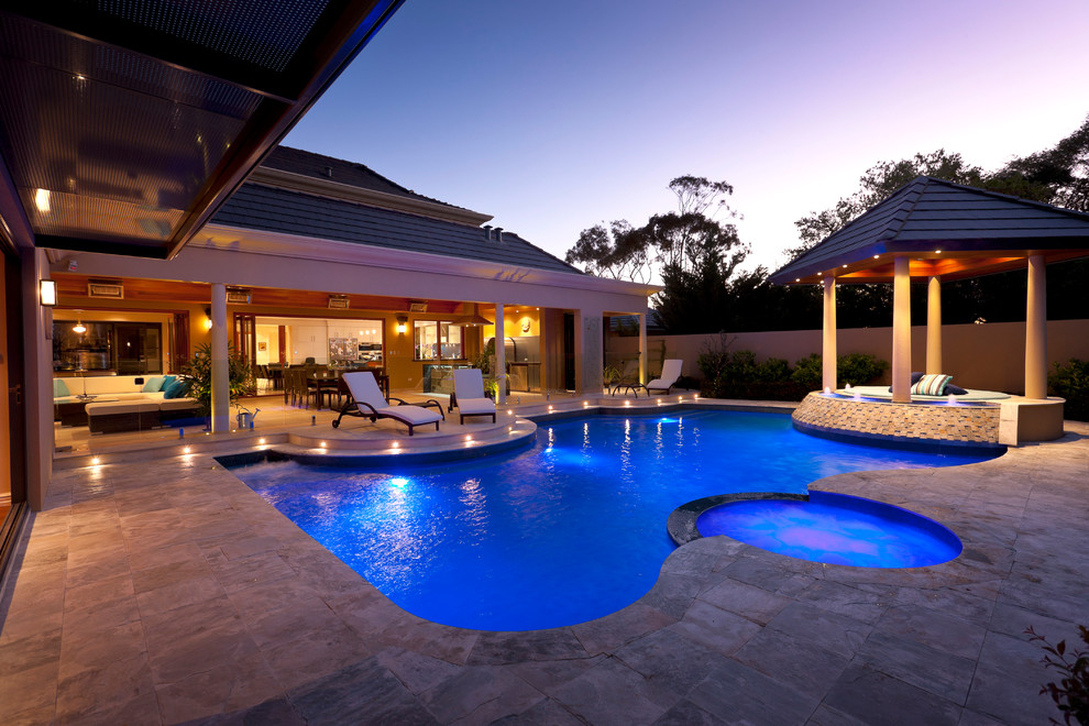 Idee per un'ampia piscina chic personalizzata dietro casa con una vasca idromassaggio e pavimentazioni in pietra naturale