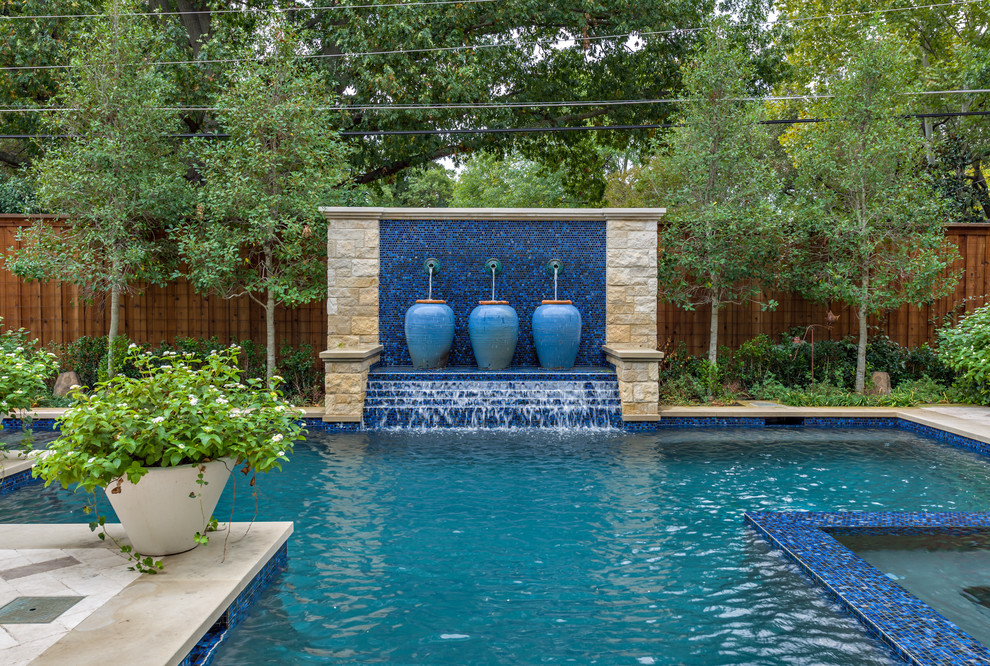 Traditional swimming pool in Dallas with a water feature.