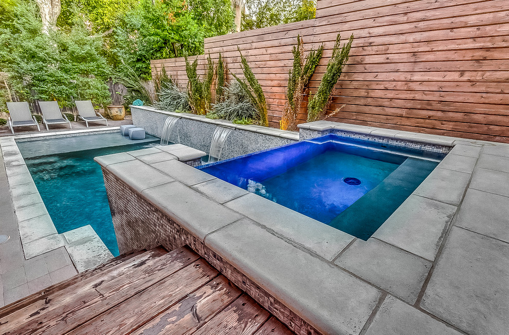 Ejemplo de piscinas y jacuzzis infinitos tradicionales renovados de tamaño medio rectangulares en patio trasero con losas de hormigón