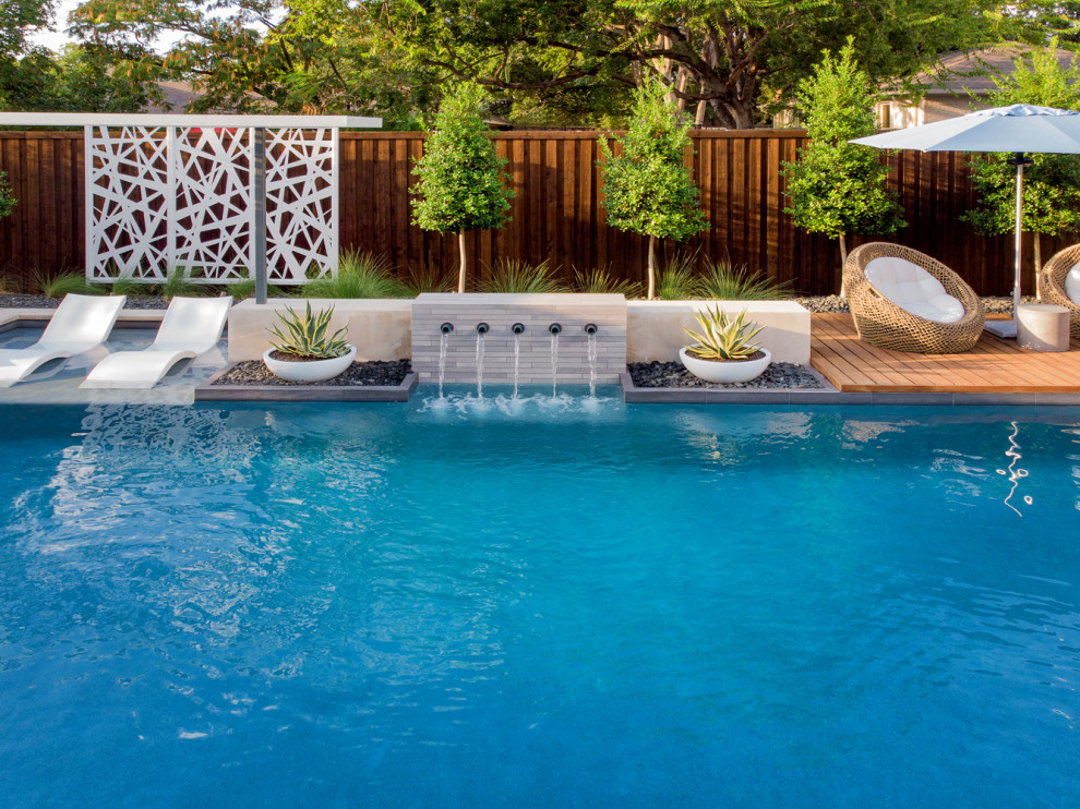 Esempio di una piscina moderna a "L" di medie dimensioni e dietro casa con lastre di cemento