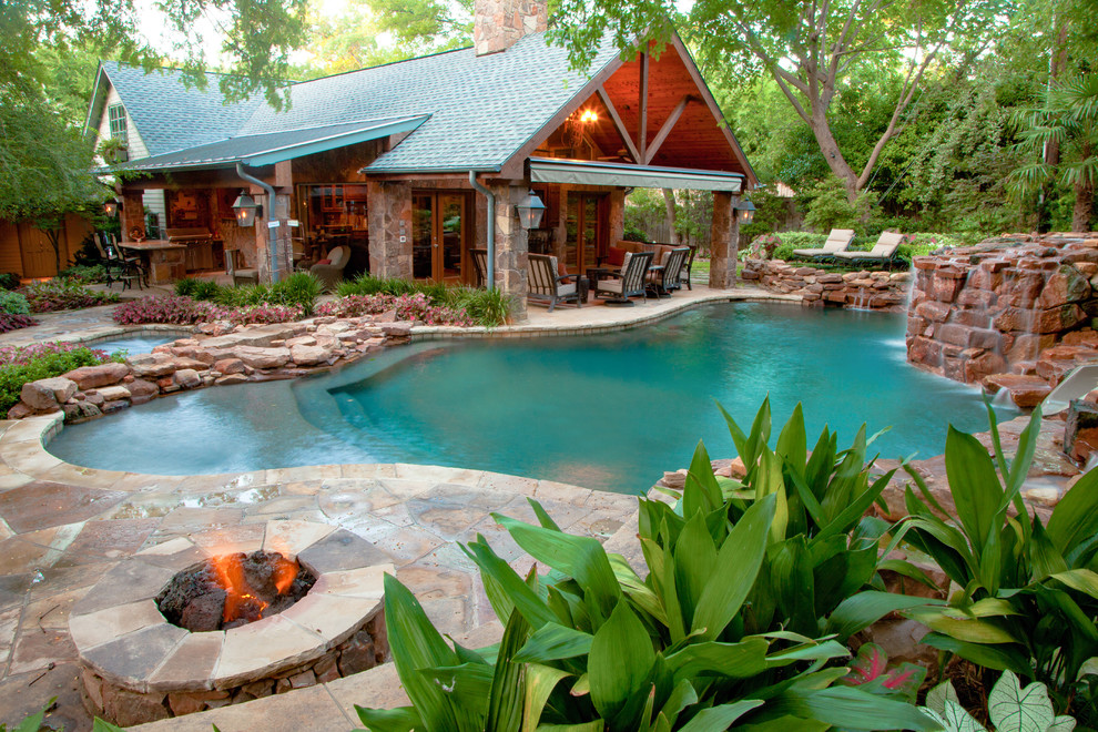 Foto de casa de la piscina y piscina natural rústica grande a medida en patio trasero con adoquines de piedra natural
