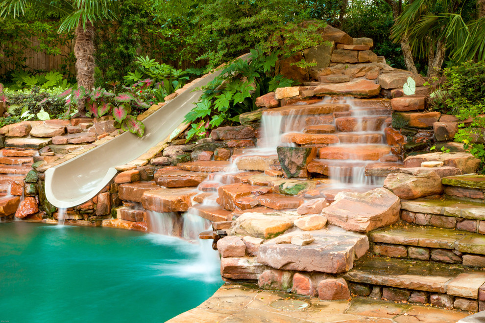Diseño de casa de la piscina y piscina natural rústica grande a medida en patio trasero con adoquines de piedra natural
