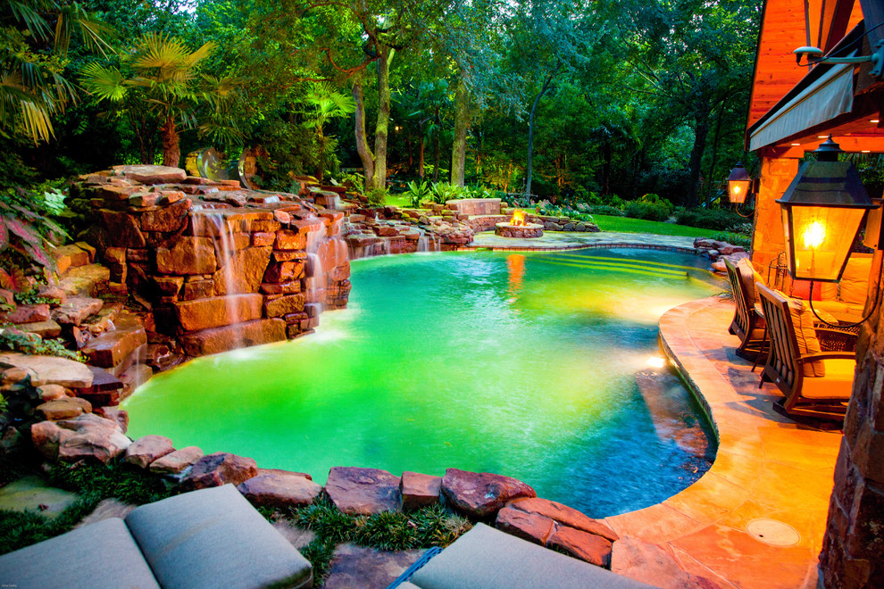 Ejemplo de casa de la piscina y piscina natural rural grande a medida en patio trasero con adoquines de piedra natural