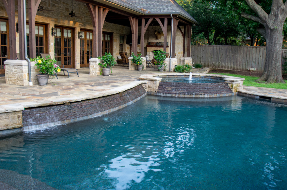Imagen de piscina con fuente rústica de tamaño medio a medida en patio trasero con adoquines de piedra natural