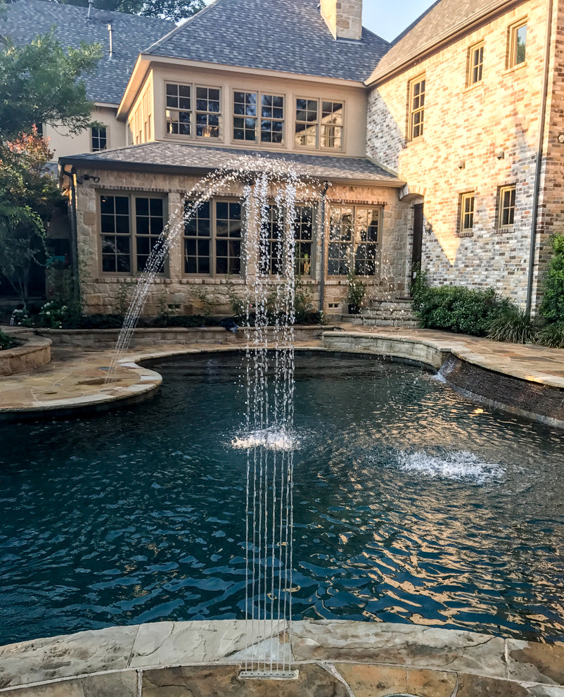 Mid-sized mountain style backyard stone and custom-shaped pool fountain photo in Dallas