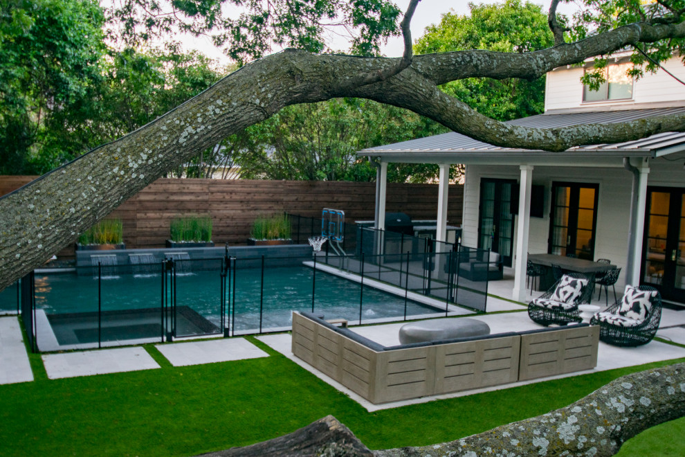 Aménagement d'une petite piscine arrière moderne sur mesure avec des solutions pour vis-à-vis et des pavés en pierre naturelle.