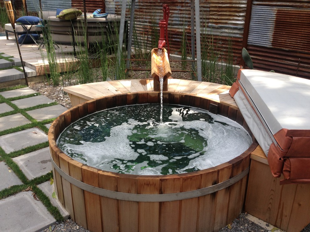 Aménagement d'une petite piscine hors-sol et arrière éclectique ronde avec un bain bouillonnant et une terrasse en bois.