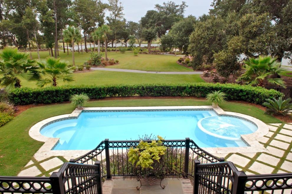 Ejemplo de piscinas y jacuzzis alargados costeros de tamaño medio a medida en patio trasero con adoquines de hormigón