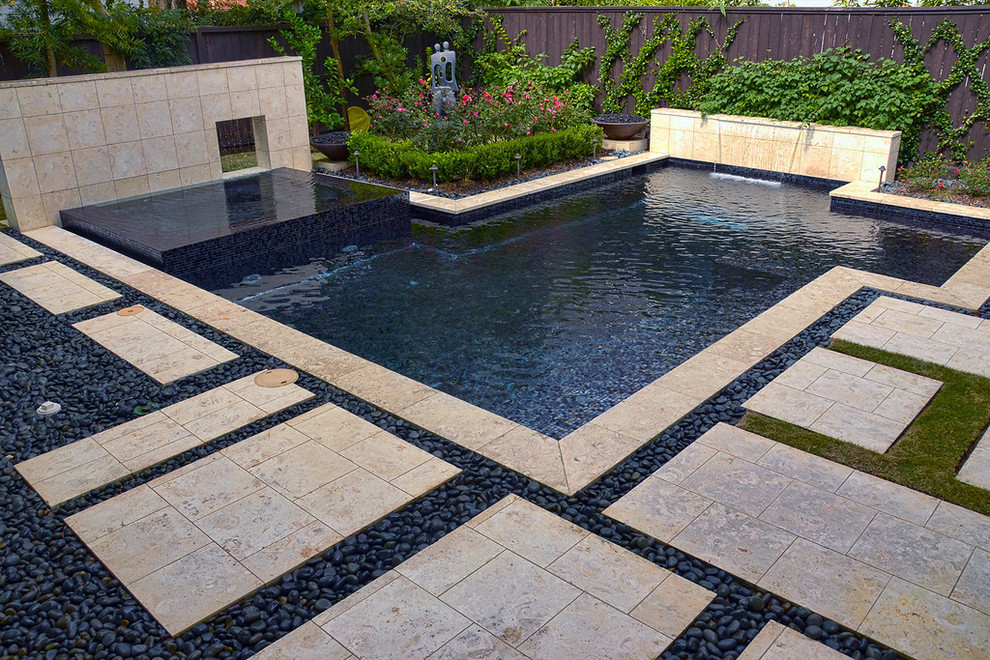 Foto di una grande piscina minimalista personalizzata dietro casa con una vasca idromassaggio e piastrelle