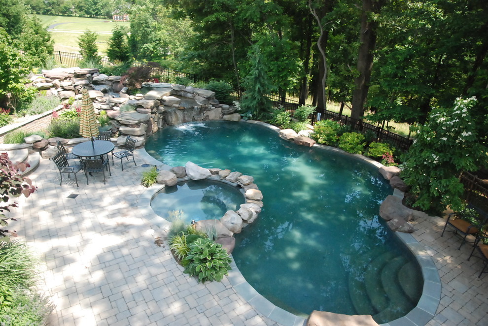 Idee per una grande piscina naturale minimal personalizzata dietro casa con pavimentazioni in cemento