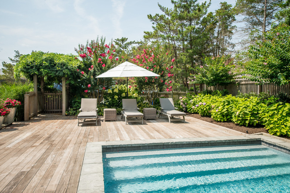 Ejemplo de piscina clásica rectangular en patio trasero con entablado
