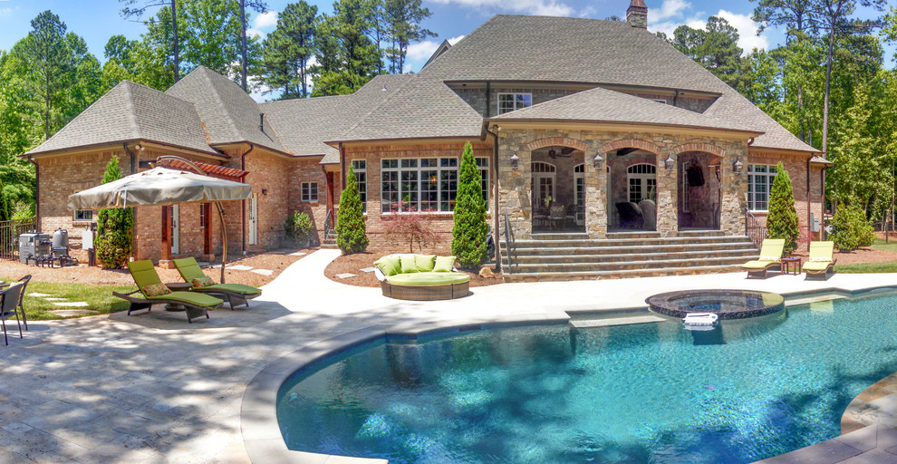 Inspiration for a large eclectic backyard stone and custom-shaped pool remodel in Charlotte
