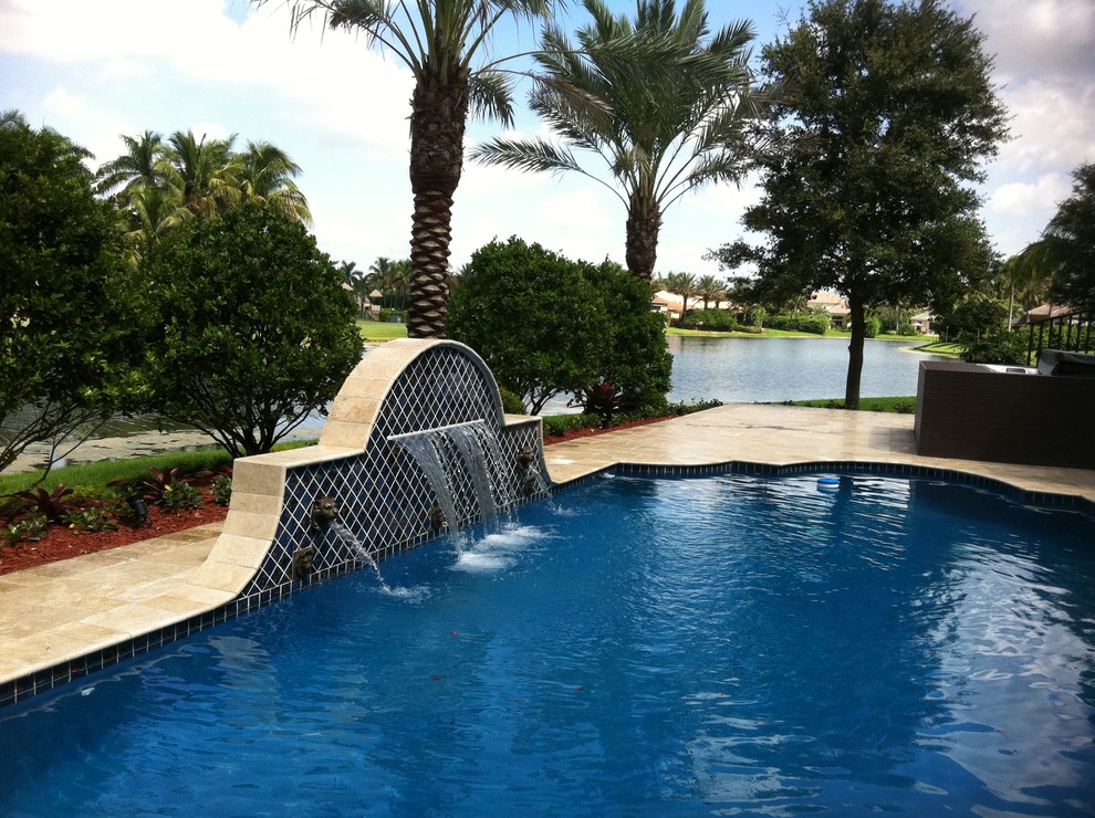 Pool fountain - mid-sized tropical backyard tile and custom-shaped lap pool fountain idea in Miami