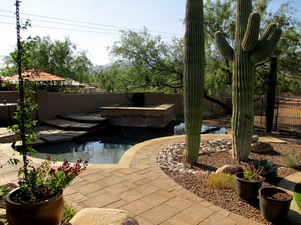 Großer Mediterraner Infinity-Pool hinter dem Haus in individueller Form mit Pool-Gartenbau und Natursteinplatten in Phoenix
