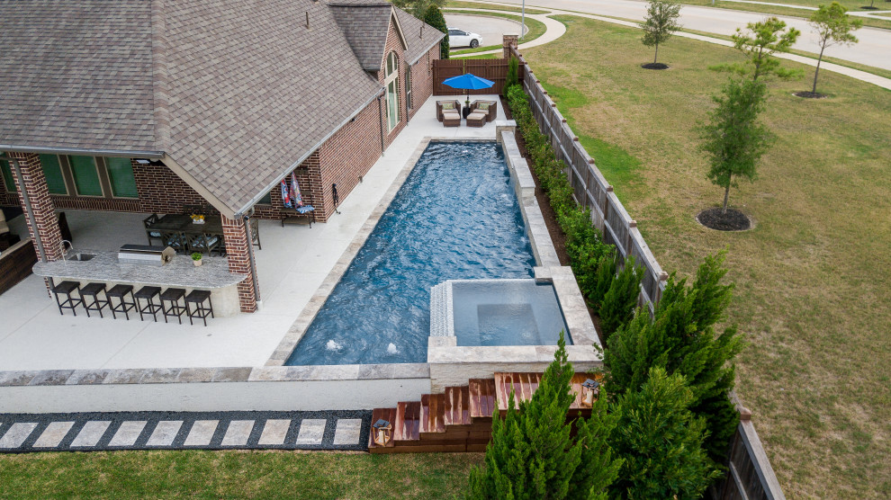 Imagen de piscina actual grande a medida en patio trasero con entablado