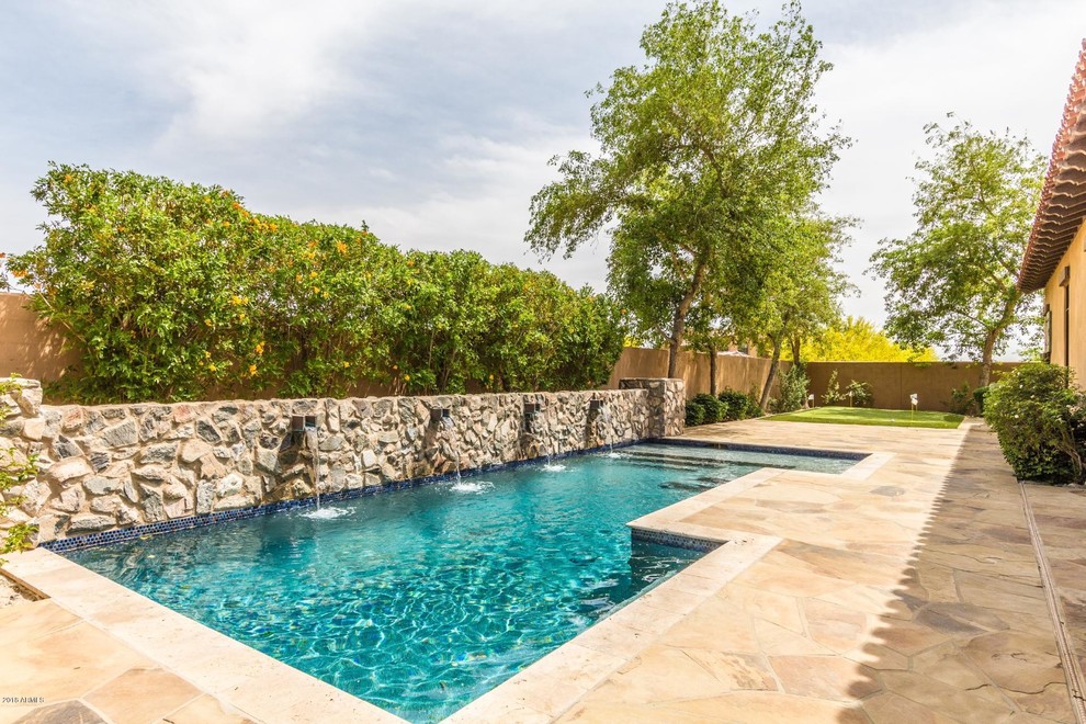 Diseño de piscina con fuente alargada mediterránea de tamaño medio rectangular en patio trasero
