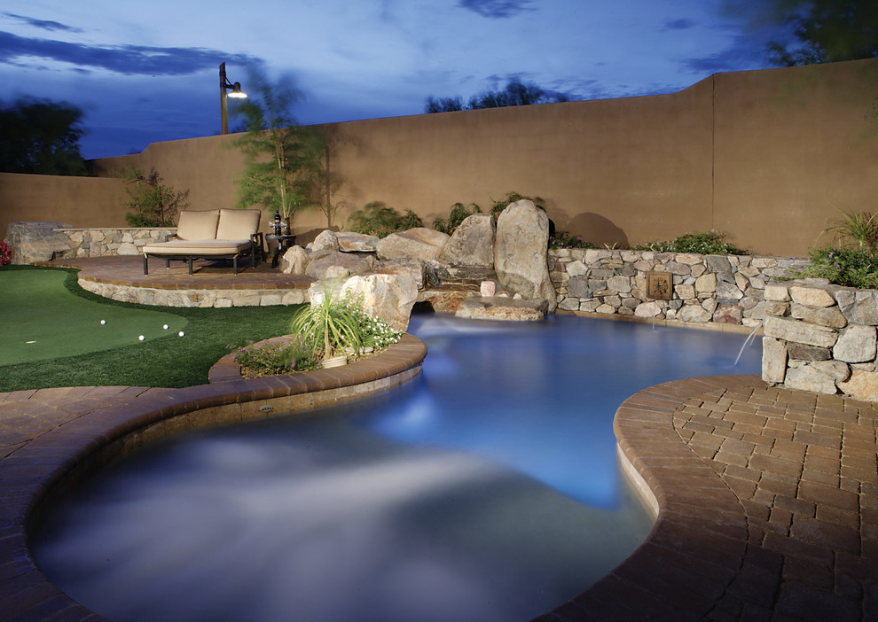 Foto de piscina natural mediterránea pequeña a medida en patio trasero con adoquines de ladrillo