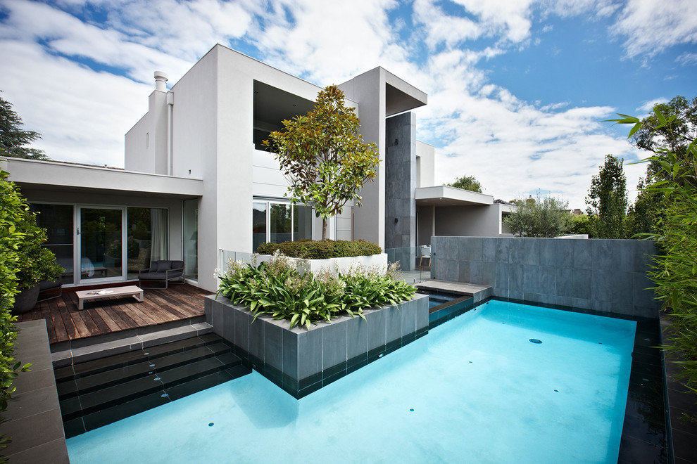 Réalisation d'une piscine design rectangle avec une terrasse en bois.