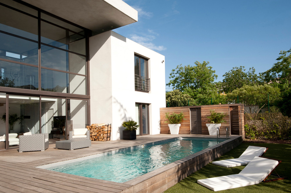 Immagine di una piscina monocorsia minimal rettangolare di medie dimensioni e dietro casa con pedane