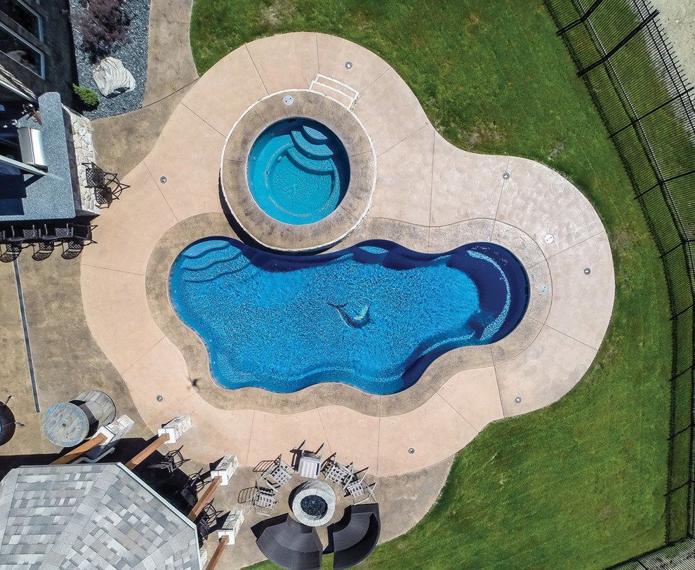 На фото: бассейн среднего размера, в форме фасоли в морском стиле с джакузи и мощением тротуарной плиткой