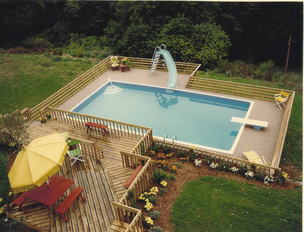 Exemple d'une piscine arrière et hors-sol moderne de taille moyenne et rectangle avec une terrasse en bois et un toboggan.