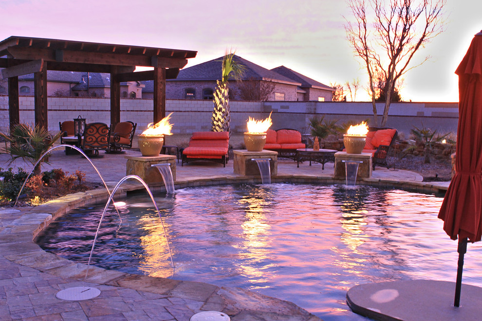 Photo of a large world-inspired back custom shaped natural swimming pool in Dallas with a water feature.