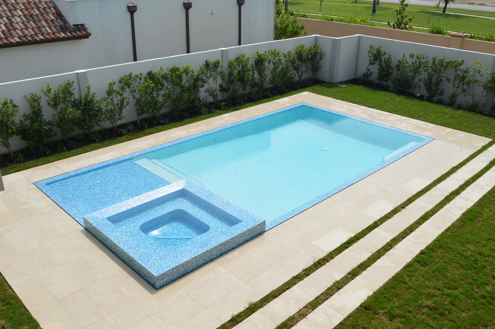 Example of a mid-sized minimalist backyard stone and rectangular infinity pool fountain design in Austin