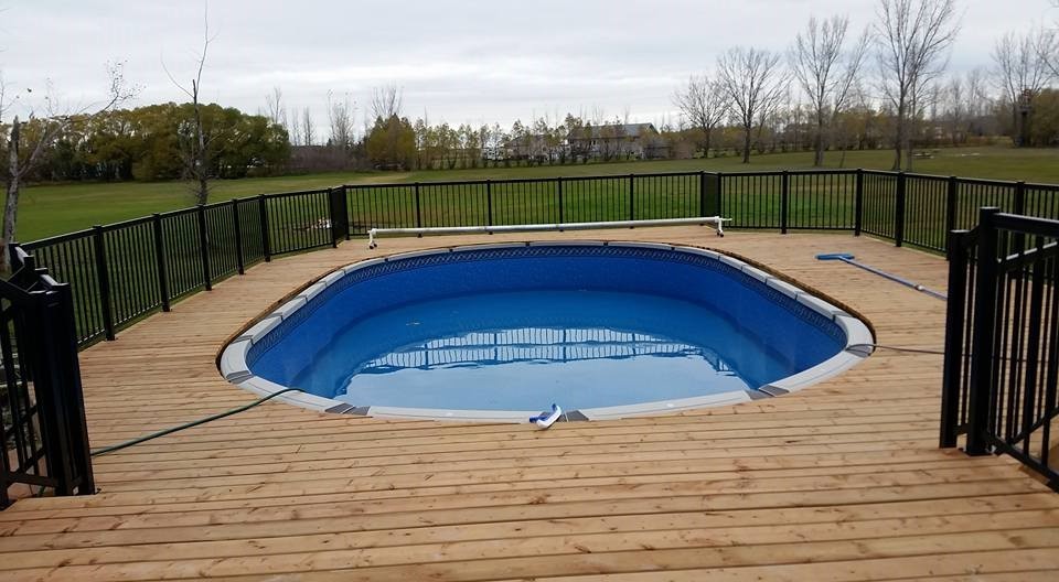 Esempio di una piscina stile americano rettangolare di medie dimensioni e dietro casa con pedane