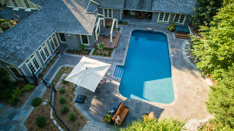 Diseño de piscinas y jacuzzis alargados clásicos extra grandes rectangulares en patio trasero con adoquines de piedra natural