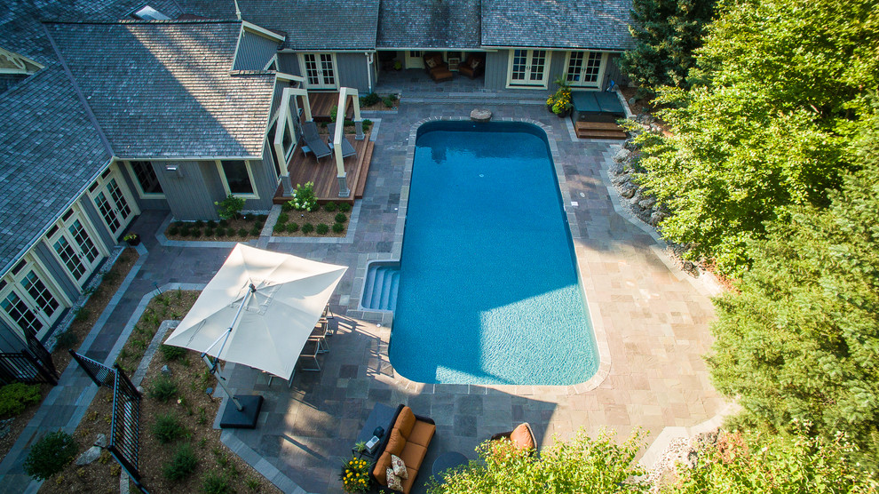 На фото: огромный спортивный, прямоугольный бассейн на заднем дворе в классическом стиле с джакузи и покрытием из каменной брусчатки с