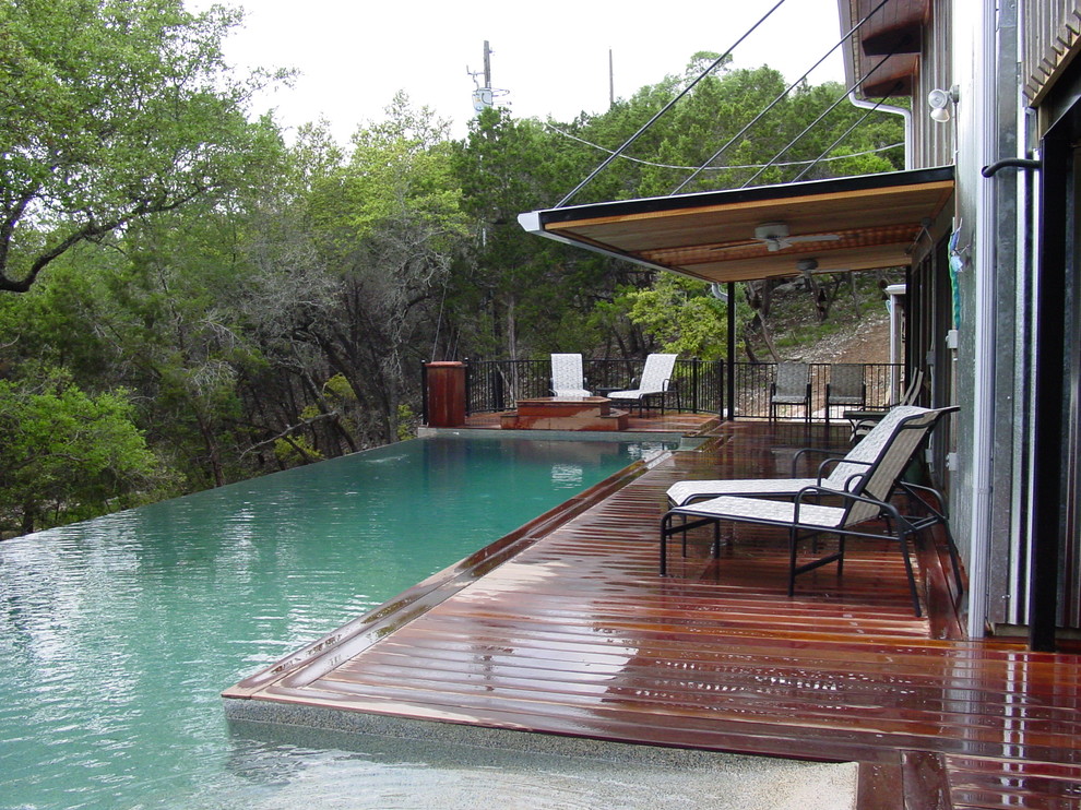 Foto de piscina infinita actual de tamaño medio en forma de L en patio trasero con entablado